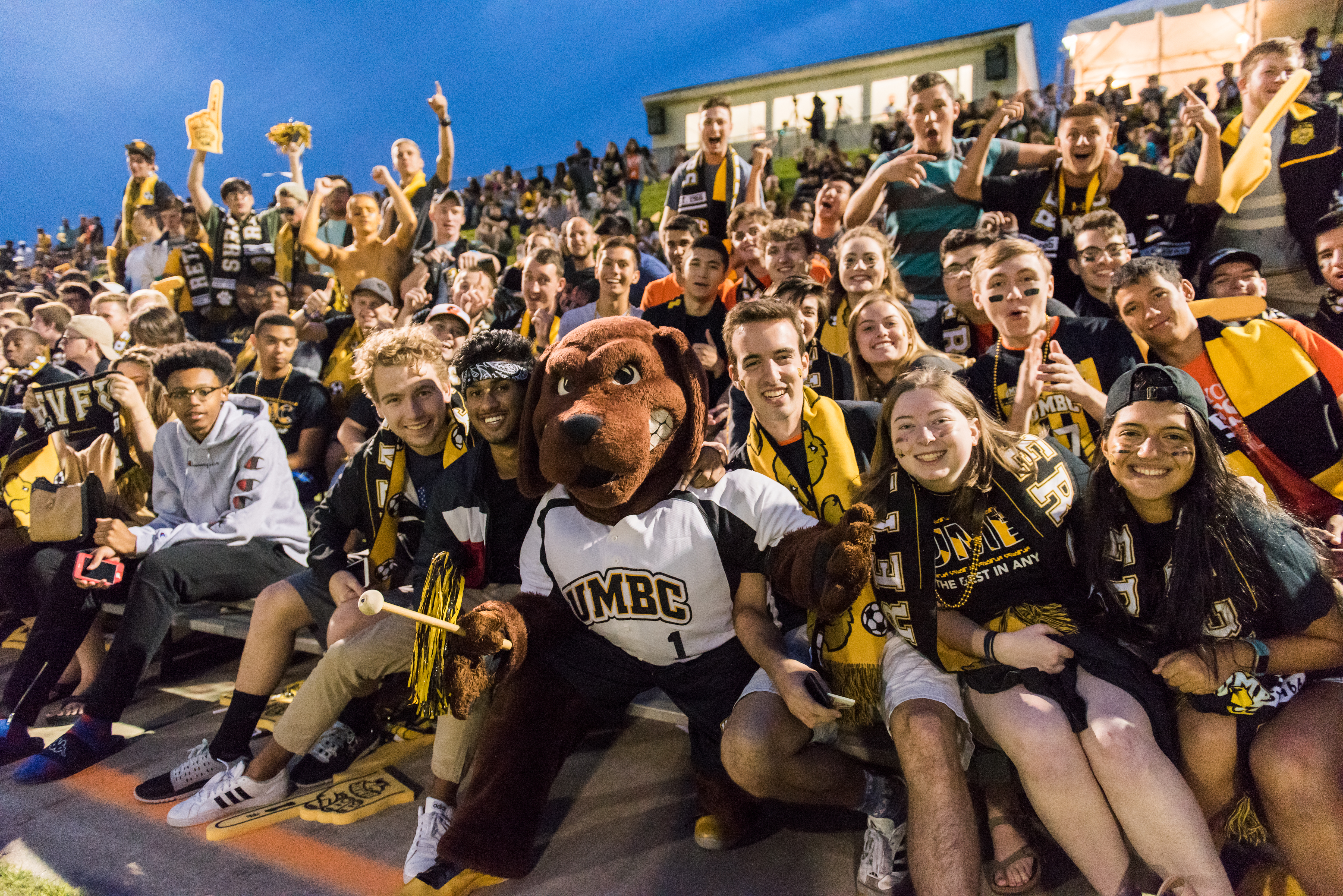 Students and True Grit outdoors at an evening soccer game