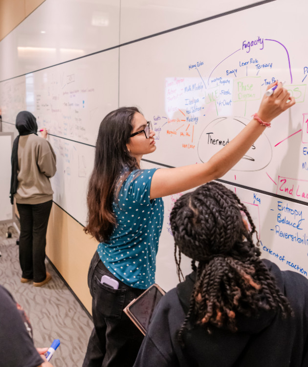 students work together at a whiteboard